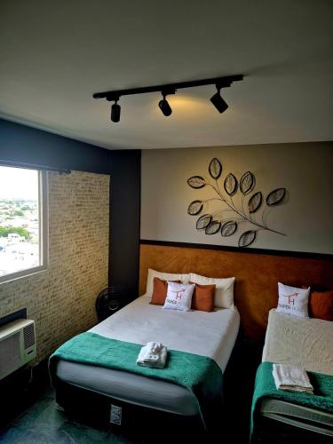 a hotel room with two beds and a window at studio estilo industrial Centro in Campos dos Goytacazes