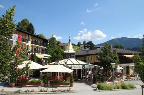 a town with tables and umbrellas and a church at Landhaus Margarethe in Hopfgarten im Brixental