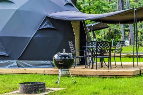 a large tent with a grill in the grass at Peaceful Dome Getaway in the Catskills in Gilboa
