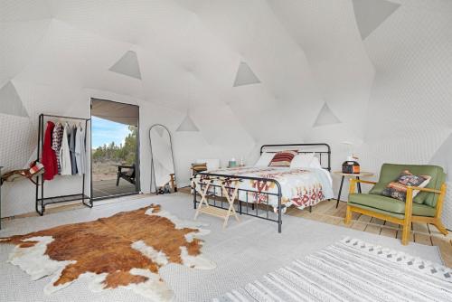 a bedroom with a bed and a green chair at Winter Nights in a Secluded Canyon Dome in Valle