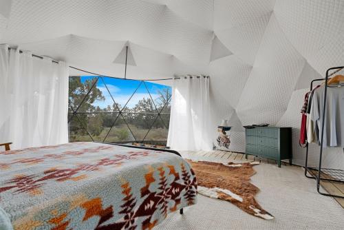 a bedroom with a bed and a large window at Winter Nights in a Secluded Canyon Dome in Valle