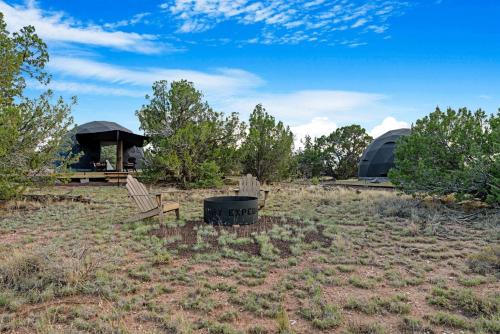 a couple of benches sitting in a field with a tent at Winter Serenity in a Luxury Glamping Dome in Valle