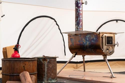 an old tv sitting on a stand next to a drum at Tranquil Winter Bell Tent Adventure in Valle