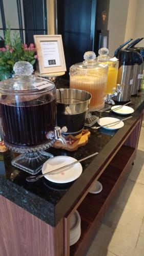 Una línea de buffet con ollas, sartenes y platos en Hotel C jaguariuna, en Jaguariúna