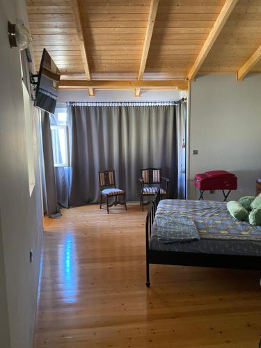 a bedroom with a bed and two chairs in it at eliamaria domus artificis in Lefkada Town
