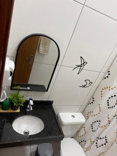 un bagno con lavandino, specchio e WC di REFUGIO DO CRUZEIRO - GRAVATa a Gravatá