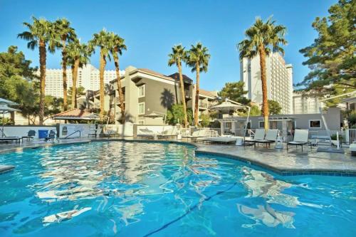a swimming pool at a resort with palm trees at Wyndham Desert Rose Resort - 1BR -Apartment with Resort Access in Las Vegas