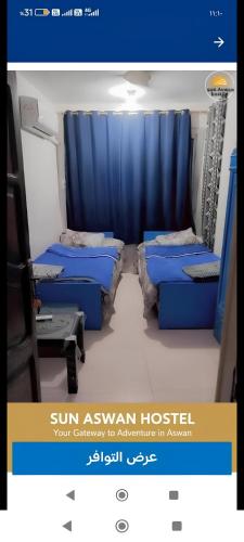 a room with two beds and a blue curtain at Sun City in Aswan