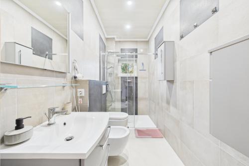 a white bathroom with a sink and a toilet at Attraktive Neubauwohnung,Balkone,WIFI,Parken im Hof,Ganze Ruhe in Bremen