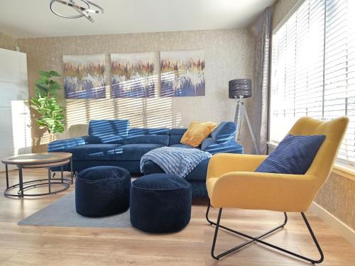 a living room with a blue couch and chairs at Entire Spacious 3-Bed Family Home, City Centre, Free Parking, Garden in Glasgow