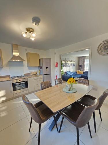 a kitchen and dining room with a wooden table and chairs at Entire Spacious 3-Bed Family Home, City Centre, Free Parking, Garden in Glasgow
