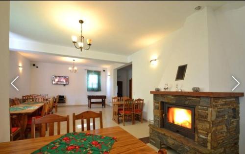 a living room with a fireplace and a dining room at Janicek in Ząb