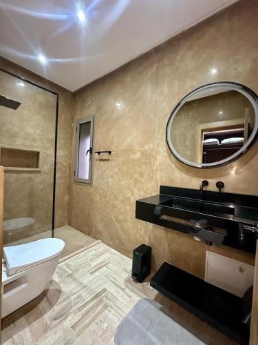 a bathroom with a toilet and a sink and a mirror at Exceptional Marrakech Villa 5 Bedrooms & Pool in Oulad Akkou