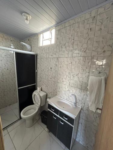 a bathroom with a toilet and a sink at Pousada e Restaurante Zanella in Candói