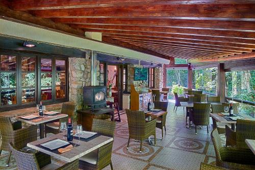 a restaurant with tables and chairs and a fireplace at Complejo Rural La Tahona De Besnes in Alles