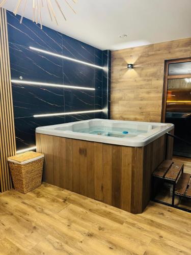 a jacuzzi tub in a room with wooden walls at Zapomniany Zdrój in Głuchołazy