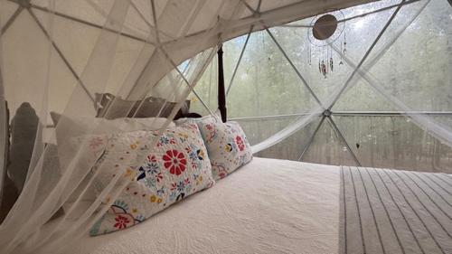Giường trong phòng chung tại Cozy Off-Grid Dome Retreat in the Woods