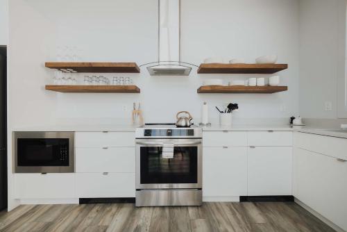 een keuken met witte kasten en een fornuis bij The Jackalope Rooftop w Fire Pit & Epic Mountain Views in Buena Vista