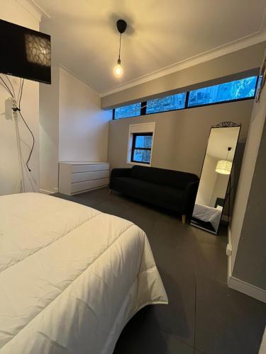 a bedroom with a bed and a couch and a mirror at Good end Oporto View in Porto