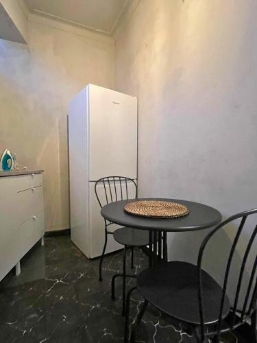 a table and chairs in a kitchen with a refrigerator at Good end Oporto View in Porto