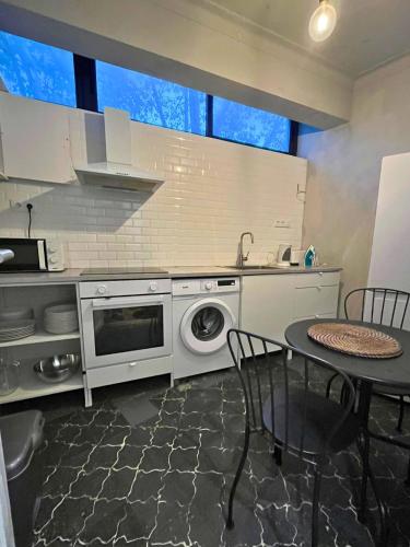 a kitchen with a washing machine and a table at Good end Oporto View in Porto