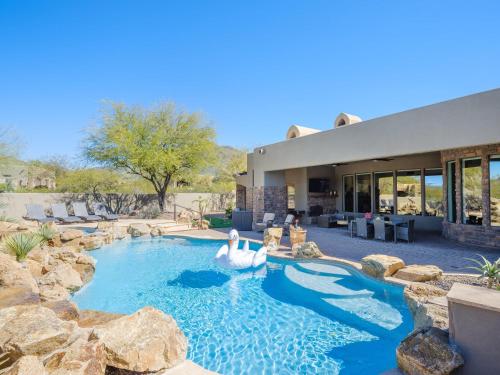 a swimming pool with two swans in a yard at Desert Mountain Majesty - Private Spa&Guest Casita in Cave Creek