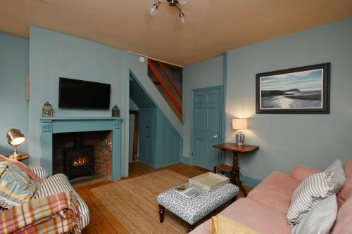 a living room with a couch and a fireplace at Pilots House Aldeburgh in Aldeburgh