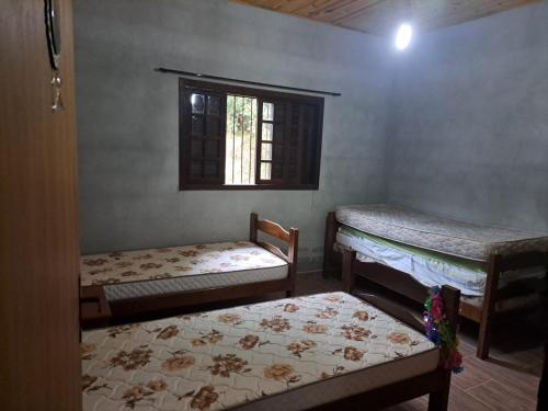 En eller flere senge i et værelse på Recanto Sonho Meu