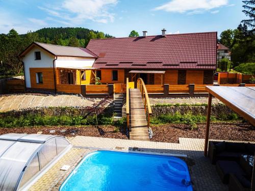 une maison avec une piscine devant une maison dans l'établissement Resort U sýrárny, à Sobotín