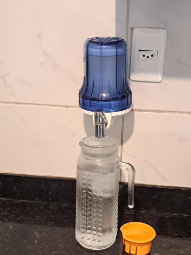 ein blauer Entsafter, der auf einer Wasserflasche steht in der Unterkunft Quarto Individual para 3 Pessoas em AP Compartilhado in João Pessoa