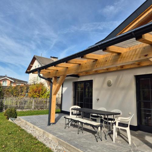 a wooden pergola on a patio with a table and chairs at Ferienwohnung Ruth in Reutte
