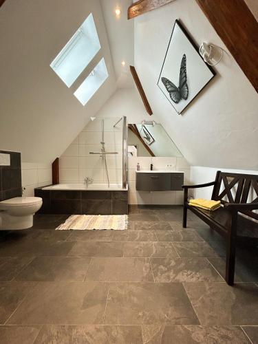 a bathroom with a shower and a toilet and a butterfly picture at Ferienwohnung Maja in Waldkirch