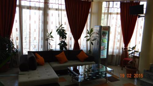 a living room with a couch and large windows at Hotel Konti in Korçë