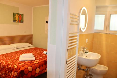 a bathroom with a bed and a sink and a mirror at My Bnb Pisa in Pisa