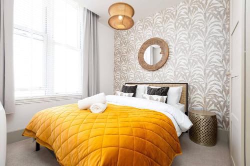 a bedroom with a bed with a yellow blanket at Apartment Ten Pelican House in Bournemouth