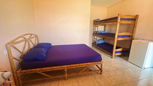 Cette chambre comprend deux lits superposés et un réfrigérateur. dans l'établissement Pousada Da Montanha, à Extrema