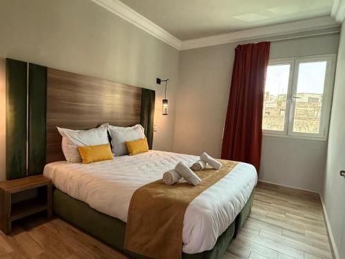 a bedroom with a large bed with two towels on it at Hamilton Suites & Appart in Casablanca