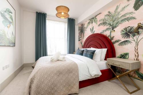 a bedroom with a large bed with a red headboard at Apartment Nine Pelican House in Bournemouth