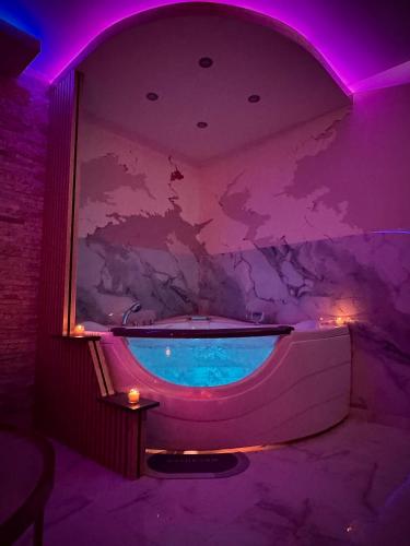 a bath tub in a room with purple lighting at Apartman Flamingos in Rača