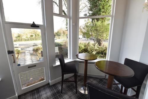 une pièce avec une table, des chaises et une fenêtre dans l'établissement Whitburn House Hotel, à Preston