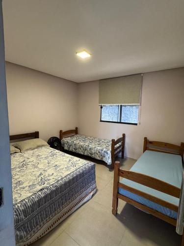 een slaapkamer met twee bedden en een raam bij CASA de Praia em Jóia do Atlântico in Ilhéus