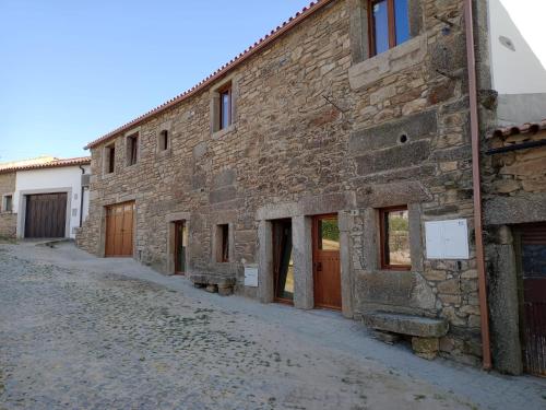 an old stone building with doors and windows on a street at Casa d'Abó Anica in Miranda do Douro