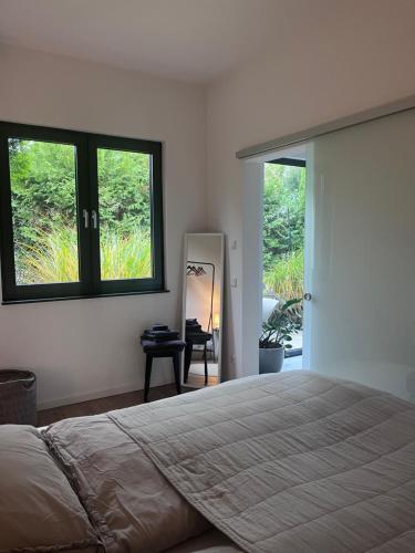 Un dormitorio con una cama grande y un espejo. en Modernes Tiny Apartment in Lage, en Lage