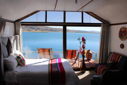 a room with a bed and a view of the water at Titicaca SUMA SARTIRI in Puno