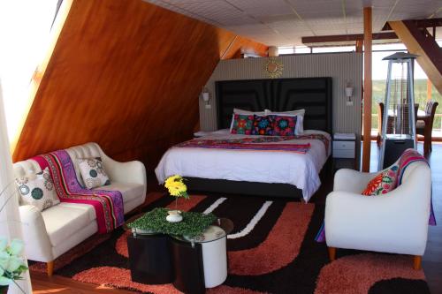 a bedroom with a bed and two chairs at Titicaca SUMA SARTIRI in Puno