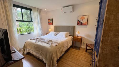 Ένα ή περισσότερα κρεβάτια σε δωμάτιο στο Casa 08 Floresta Boa Vista - Piscina Privativa e Lounge com Deck em Meio à Natureza