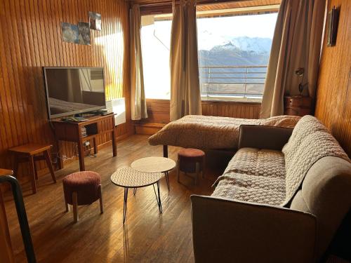 ein Wohnzimmer mit Sofa und Fernseher in der Unterkunft Appartement au pied des pistes in Forest des Baniols