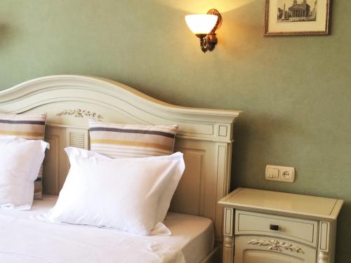 a bed with a white headboard and a side table at Aparthotel in Chişinău