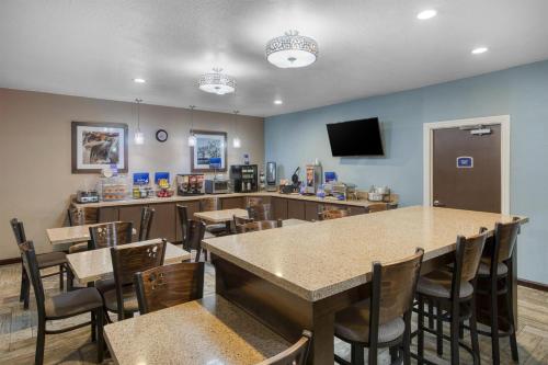 un restaurant avec une table, des chaises et une télévision dans l'établissement Best Western Lake Conroe Inn, à Montgomery