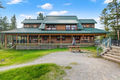a large wooden house with a picnic table in front of it at HI Lake Louise Alpine Centre - Hostel in Lake Louise